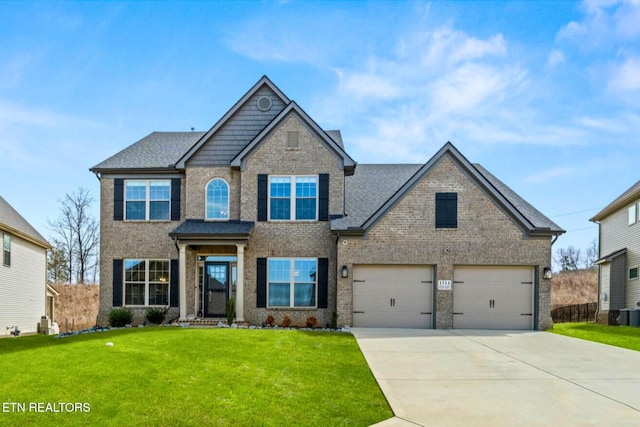 view of front of property featuring a front yard, roof with shingles, concrete driveway, a garage, and brick siding