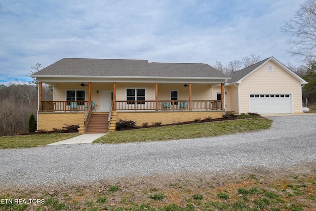 ranch-style house featuring a ceiling fan, gravel driveway, covered porch, a shingled roof, and a garage