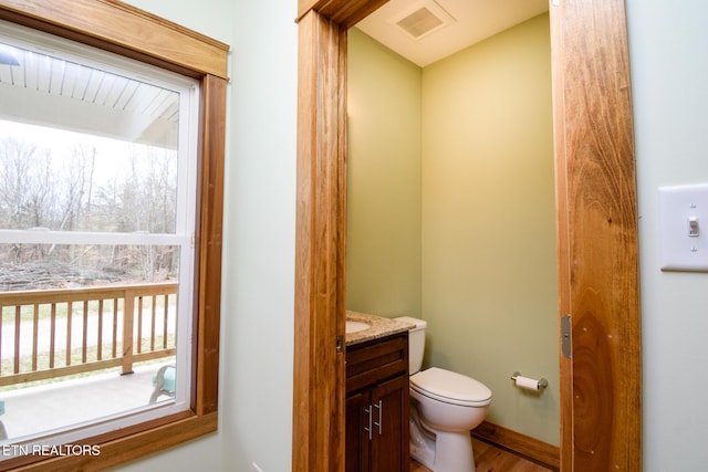 bathroom with visible vents, toilet, and vanity