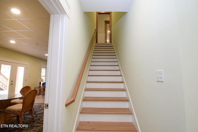 stairway featuring recessed lighting and a drop ceiling