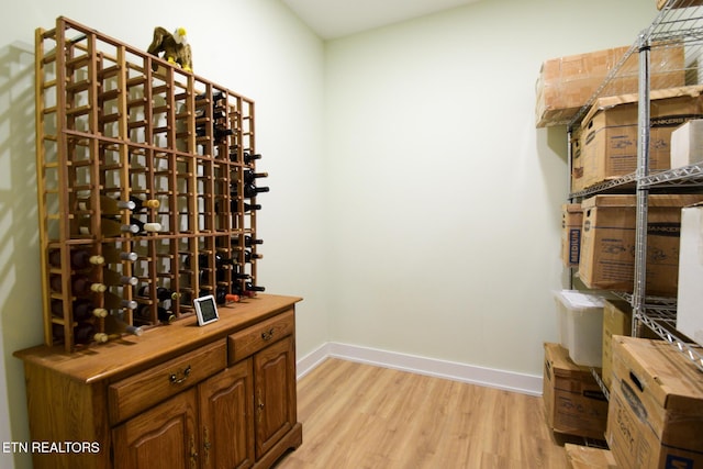 wine room featuring baseboards and light wood-style floors