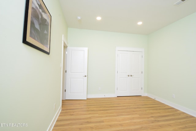 empty room featuring visible vents, recessed lighting, light wood-type flooring, and baseboards