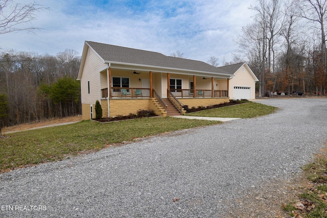 ranch-style house featuring a front yard, a ceiling fan, covered porch, and driveway