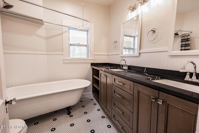 717 N Charles Seivers Blvd, Clinton, TN 37716 - bathroom featuring wainscoting, a soaking tub, double vanity, and a sink