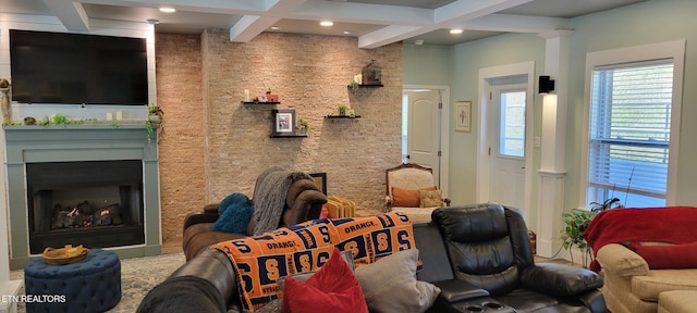 living area with beamed ceiling, a warm lit fireplace, and coffered ceiling