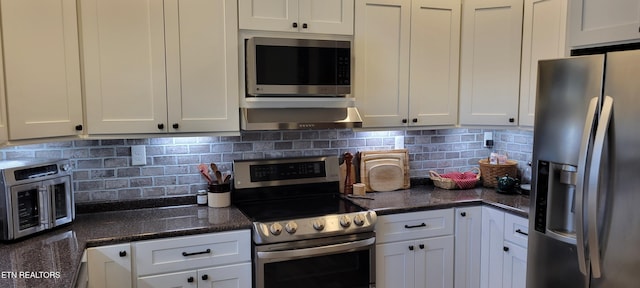 kitchen featuring decorative backsplash, dark stone counters, appliances with stainless steel finishes, and white cabinetry