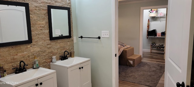 bathroom with a sink, two vanities, and wood finished floors