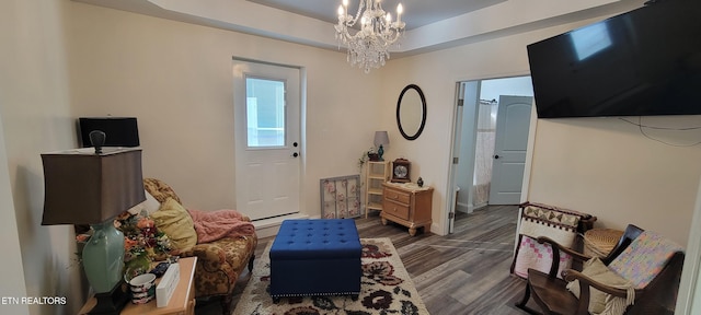 interior space with a raised ceiling, an inviting chandelier, and dark wood-style flooring