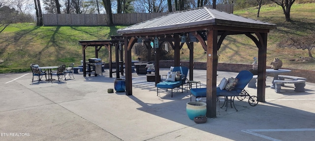 view of community with a gazebo, a patio area, and fence