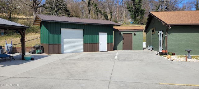 exterior space with an outbuilding, metal roof, and a detached garage