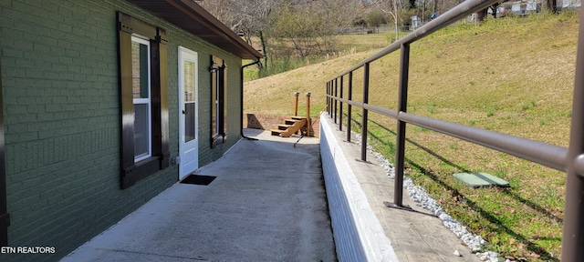 view of home's exterior with brick siding, a lawn, and a rural view