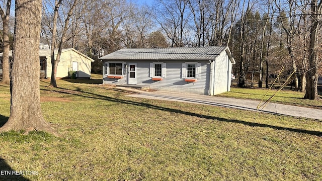 ranch-style house featuring metal roof and a front yard