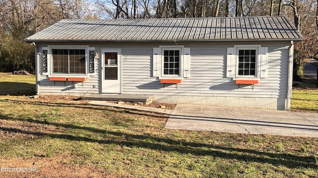 view of front of house with a front lawn and metal roof