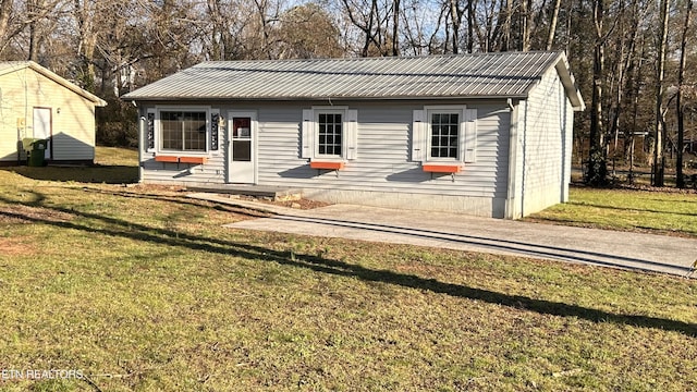 view of front facade with metal roof and a front yard