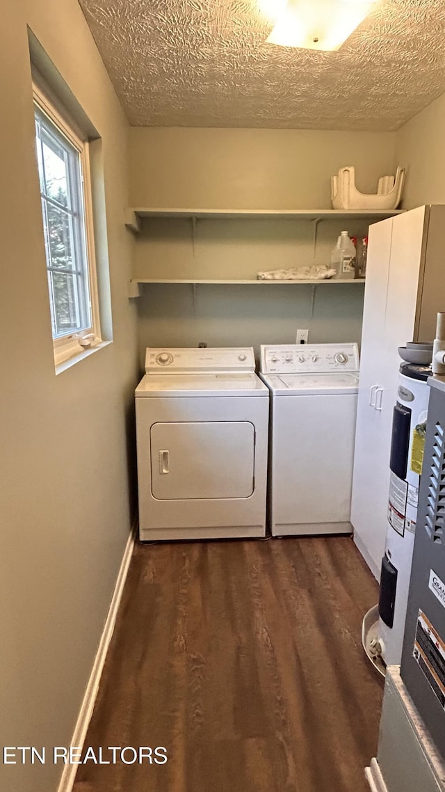 clothes washing area with laundry area, washing machine and dryer, a textured ceiling, and dark wood-style flooring