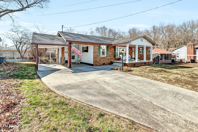 view of front facade with driveway, a porch, a front yard, crawl space, and an attached carport