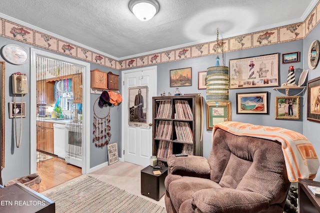 sitting room featuring light colored carpet, a textured ceiling, and crown molding