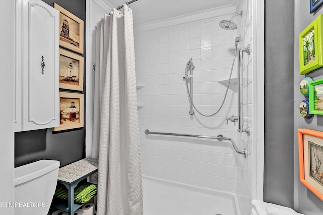 bathroom featuring toilet and a stall shower