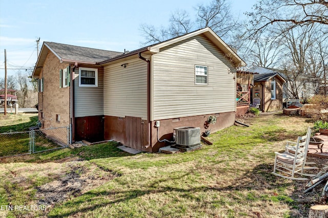 view of home's exterior with central AC unit, fence, a yard, and a gate