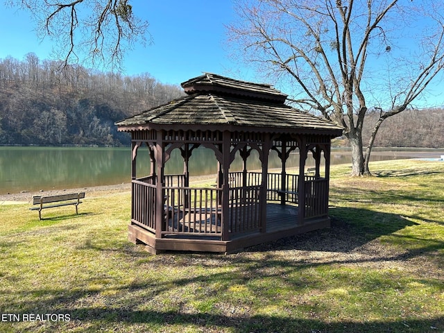 view of community with a gazebo, a lawn, a view of trees, and a water view