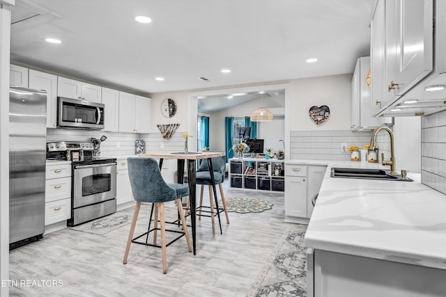 kitchen with white cabinetry, tasteful backsplash, appliances with stainless steel finishes, and a sink