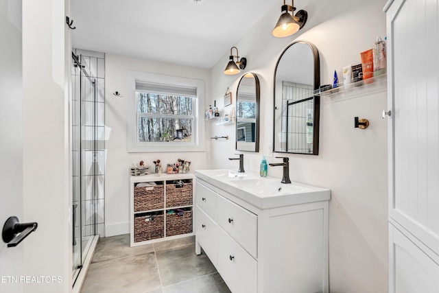 full bathroom with double vanity, tiled shower, and a sink