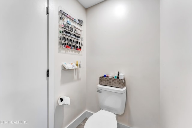 bathroom with toilet and baseboards