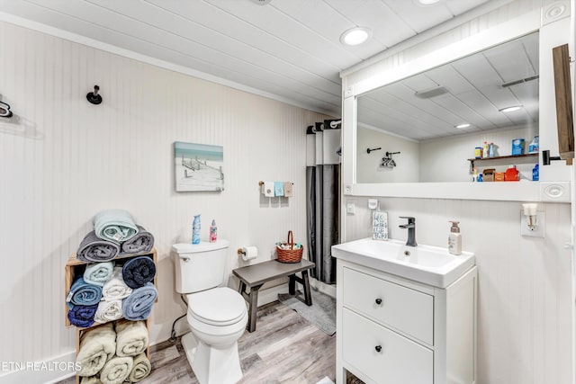 bathroom featuring toilet, wood finished floors, and vanity