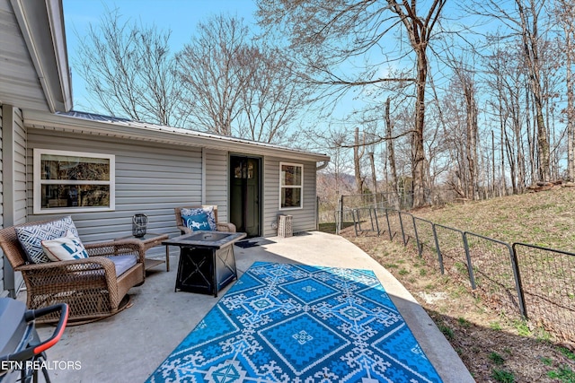 view of patio / terrace featuring an outdoor living space with a fire pit and fence