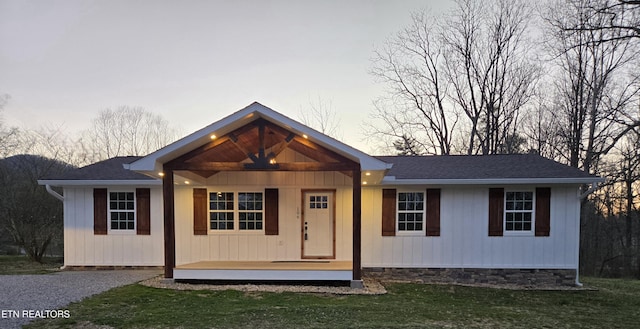 view of front of house with a porch, a front yard, roof with shingles, and crawl space