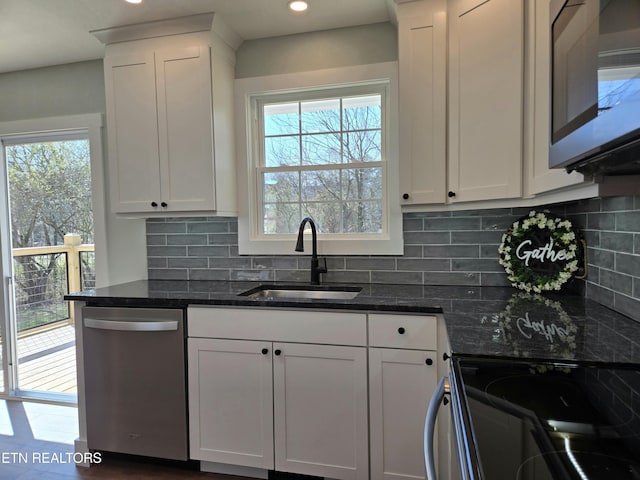 kitchen featuring a sink, stainless steel appliances, a healthy amount of sunlight, and white cabinets