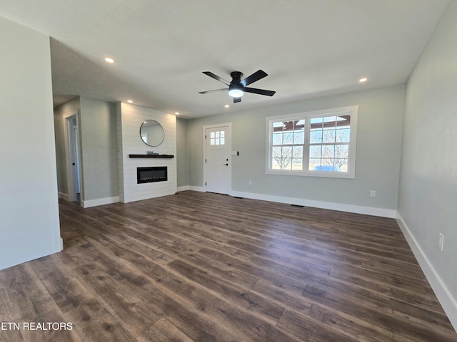 unfurnished living room with dark wood-style floors, recessed lighting, a fireplace, and baseboards