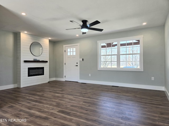 entrance foyer featuring recessed lighting, a large fireplace, baseboards, and dark wood-style flooring