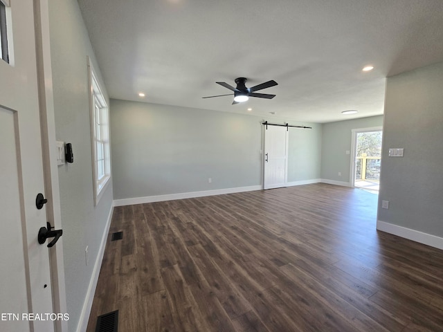 unfurnished room featuring a ceiling fan, baseboards, recessed lighting, dark wood-style flooring, and a barn door