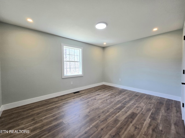 unfurnished room with recessed lighting, visible vents, baseboards, and dark wood-style flooring