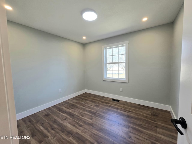 empty room featuring visible vents, recessed lighting, dark wood-type flooring, and baseboards