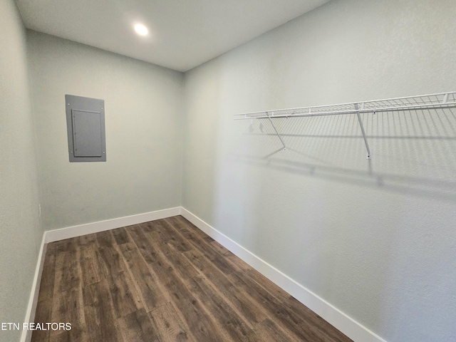 spacious closet with dark wood-type flooring and electric panel