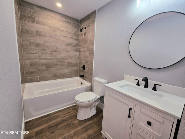 full bathroom with toilet, wood finished floors,  shower combination, baseboards, and vanity