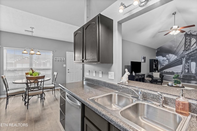 kitchen featuring a sink, stainless steel dishwasher, dark countertops, ceiling fan with notable chandelier, and light wood-type flooring