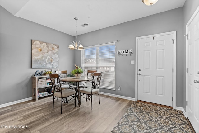 dining room with visible vents, baseboards, an inviting chandelier, and wood finished floors