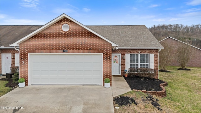 view of front of house featuring brick siding, an attached garage, driveway, and roof with shingles