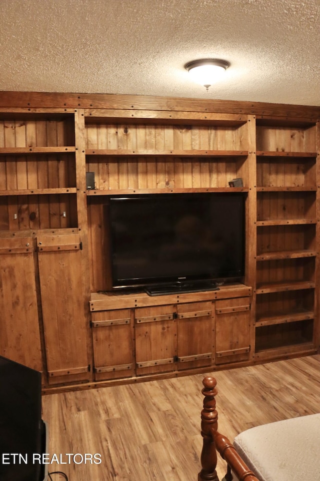 living area with light wood-style flooring and a textured ceiling