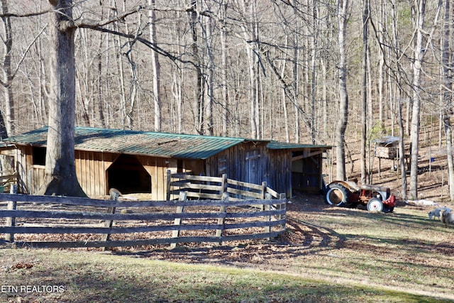 view of horse barn with a view of trees