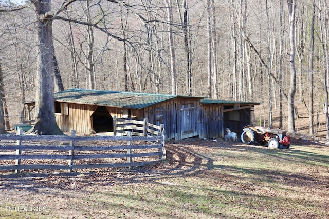 view of outdoor structure with an outbuilding, an exterior structure, and a view of trees