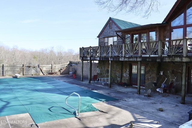 view of swimming pool featuring a fenced in pool, fence, a deck, a patio, and a diving board