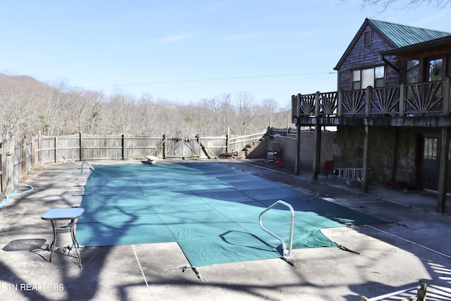 view of pool featuring a fenced in pool, a wooden deck, a fenced backyard, and a patio area