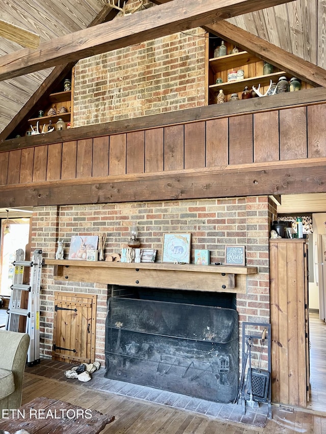 interior details featuring beamed ceiling, wood ceiling, wood finished floors, and a fireplace