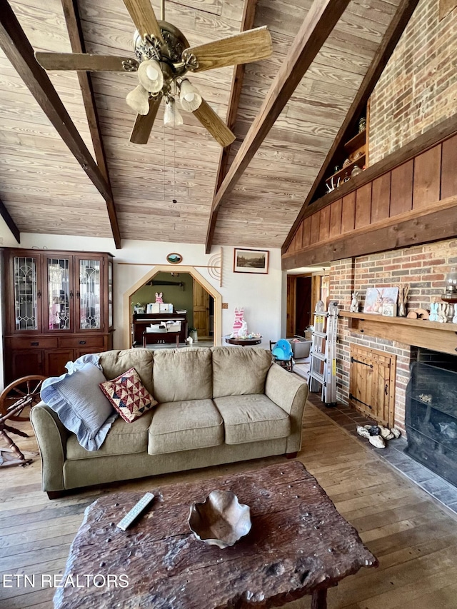 living room with beamed ceiling, wood ceiling, a fireplace, high vaulted ceiling, and wood-type flooring