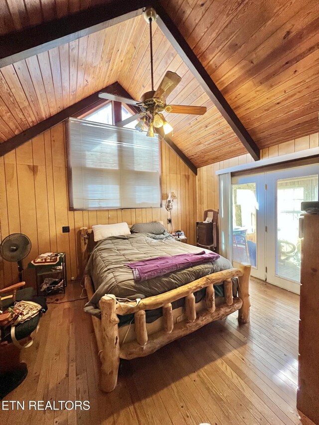 bedroom with lofted ceiling with beams, hardwood / wood-style floors, wooden ceiling, and access to exterior