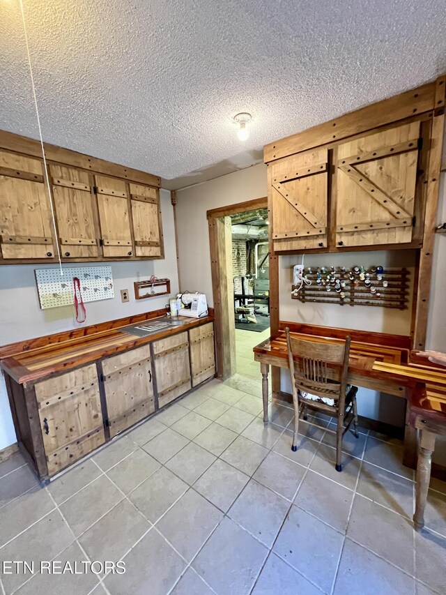 kitchen with light tile patterned floors and a textured ceiling